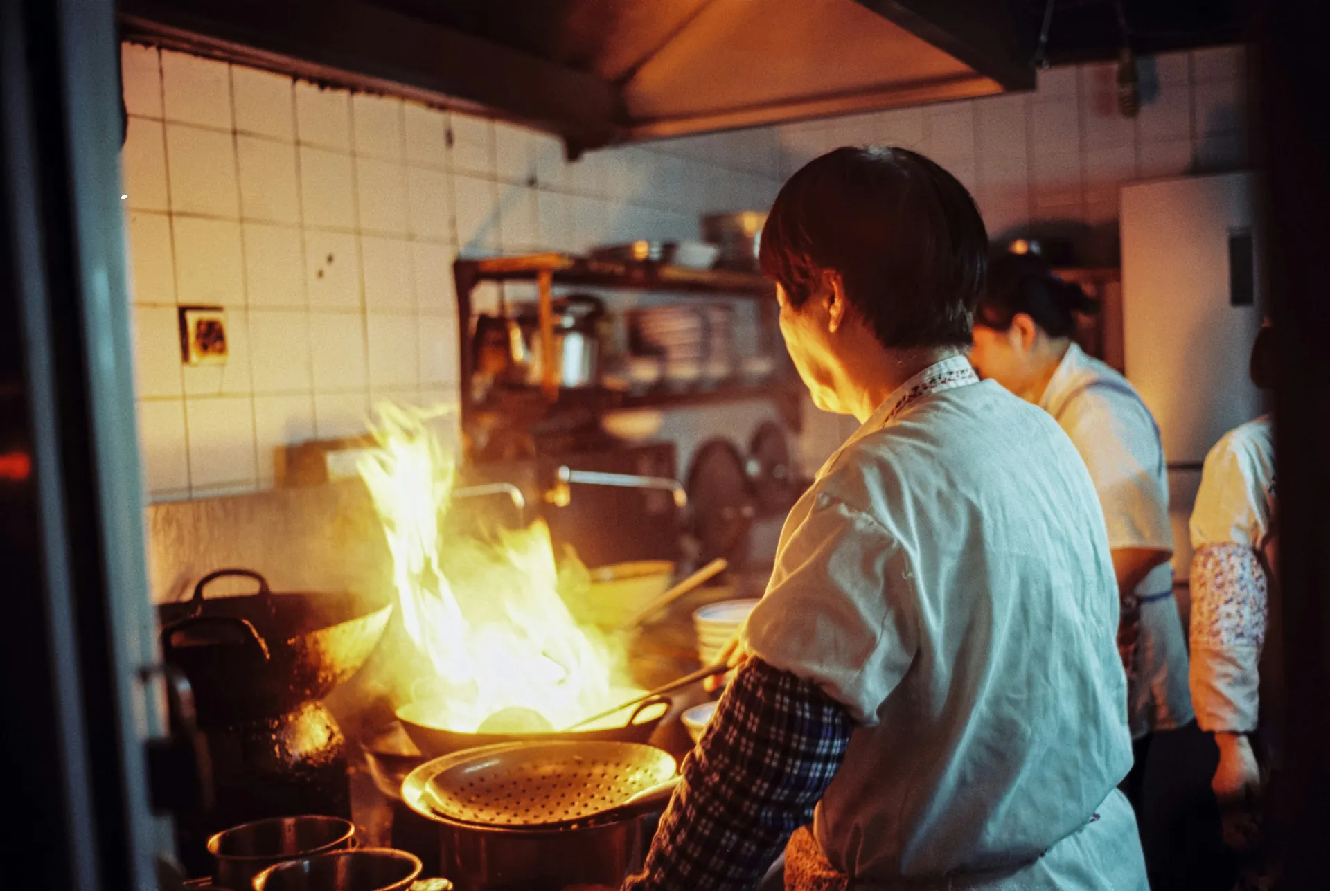 Chefkoks die samen in de keuken werken boven de wok